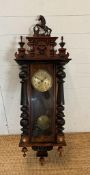 A mahogany cased eight day Vienna wall clock with finial and horse crown and brass dial and pendulum