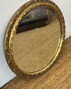 A circular wooden framed gold painted hall mirror