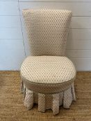 A floral upholstered skirted bedroom chair