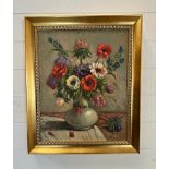 An oil on canvas still life of flowers in a white vase signed lower right 39cm x 48cm