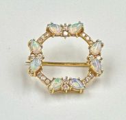A circular brooch with opal and diamonds, set in 18ct yellow gold, approximately 22mm in diameter
