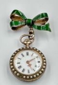 A green enamel and silver pocket watch with Fleur De Lis decoration along with seed peals around the