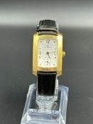 A Baume & Mercier Hampton Milleis 18ct Yellow Gold wristwatch with pouch and papers.