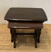 A nest of two stained oak Mid Century side tables (H39cm W45cm D30cm)