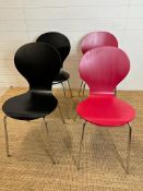 Four butterfly back dining chairs on chrome legs with laminate finish, two red and two black