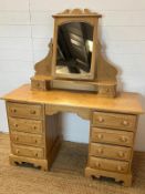 A pine dressing table with four drawers each side and a pine mirror (H74cm W122cm D47cm)