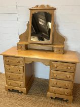 A pine dressing table with four drawers each side and a pine mirror (H74cm W122cm D47cm)
