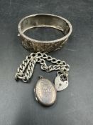 Three items of silver jewellery, bangle, bracelet and locket.