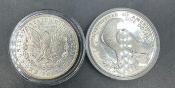 Two American Dollars:1984 Olympiad silver dollar and a 1883 Liberty Dollar.