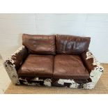 A two seater leather and cow hide sofa (H84cm 175cm D95cm SH41cm)