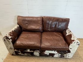 A two seater leather and cow hide sofa (H84cm 175cm D95cm SH41cm)