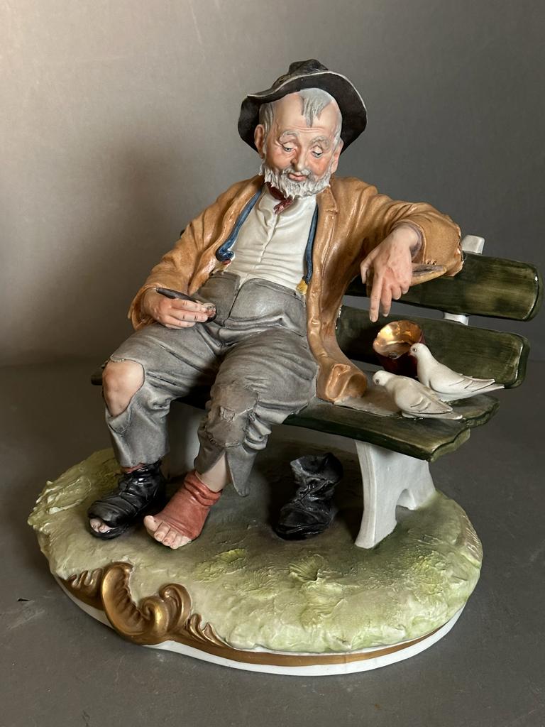 A selection of four Capodimonte figures to include Gentleman on benches, a man with a basket and a - Image 5 of 6