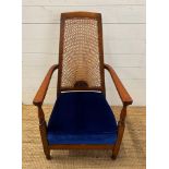 An oak cane backed arts and crafts style arm chair upholstered in blue