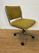 A Mid Century chrome office chair in a green upholstery on castors