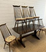 A dark Ercol dining table and five Ercol Windsor Goldsmith dining chairs (H72cm W147cm D84cm)