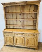 A pine dresser with three shelve plate rack sat upon a three drawer over three cupboard base (H211cm