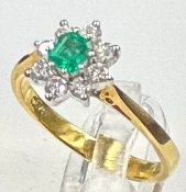 An Emerald and diamond daisy style 18ct gold ring, approximate size J