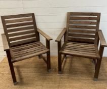 A pair of slatted wooden garden chairs