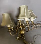 A brass five arm ceiling light with green satin shade