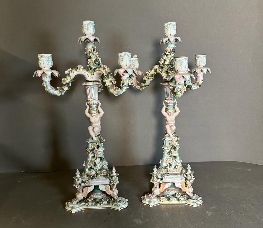 A pair of figural four arm Dresden ceramic candle stick