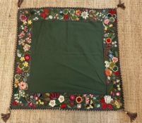 A green applique table cloth or wall hanging with a floral border 96cm x 96cm