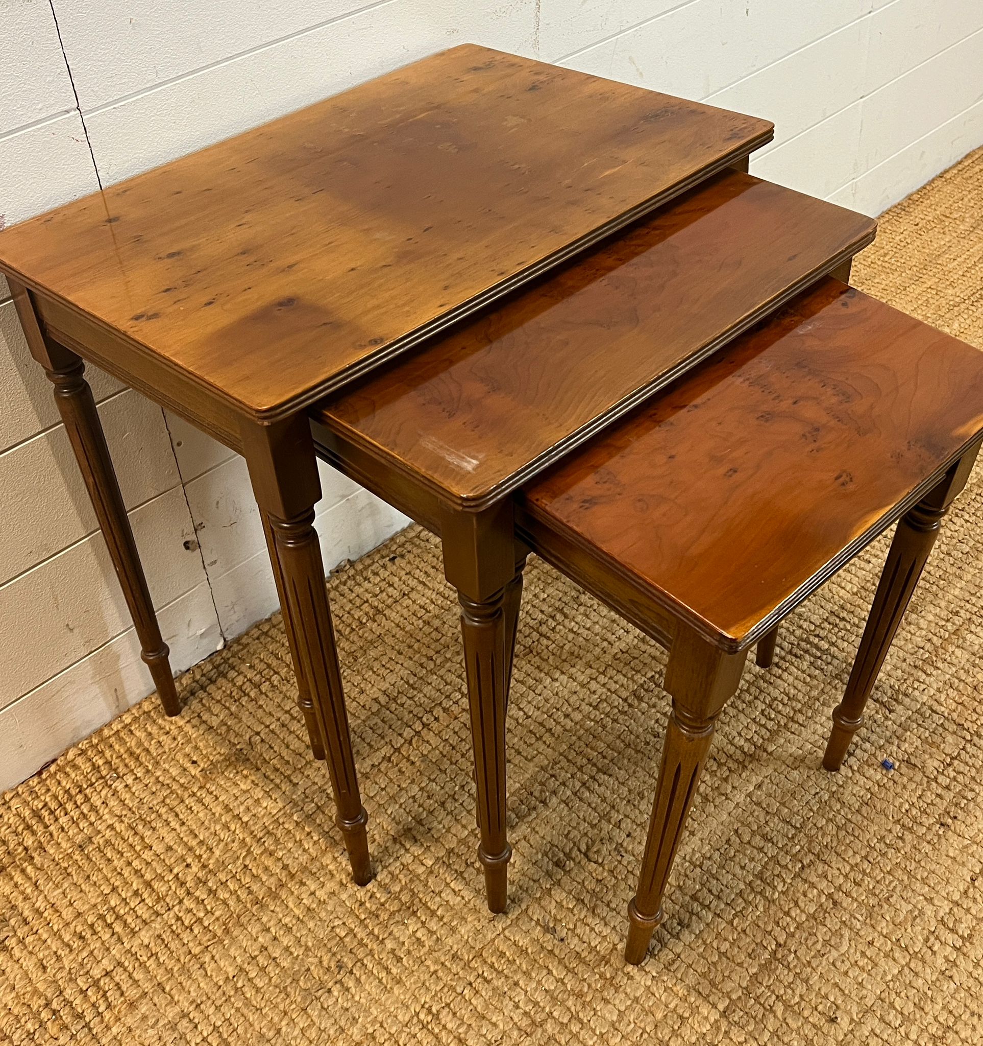 A nest of three table on fluted legs (H54cm W56cm D38cm)