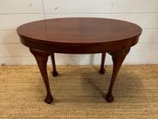 An oval mahogany side table on claw and ball feet (H46cm W75cm D51cm)