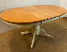 A pine topped extendable dining table on a white painted pedestal base (150cm x 106cm at extension