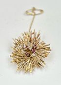 A 9ct gold brooch with floral theme and four small rubies. Approximate total weight 8.6g
