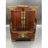 An Oriental themed jewellery box in hardwood with brass decoration. (23.5cm H x 17cm W x 11cm D)