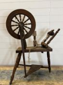 A wooden spinning wheel on turned legs