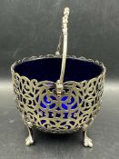 A silver plate pierced sugar bowl with blue glass insert