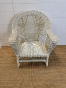 A white painted wicker arm chair