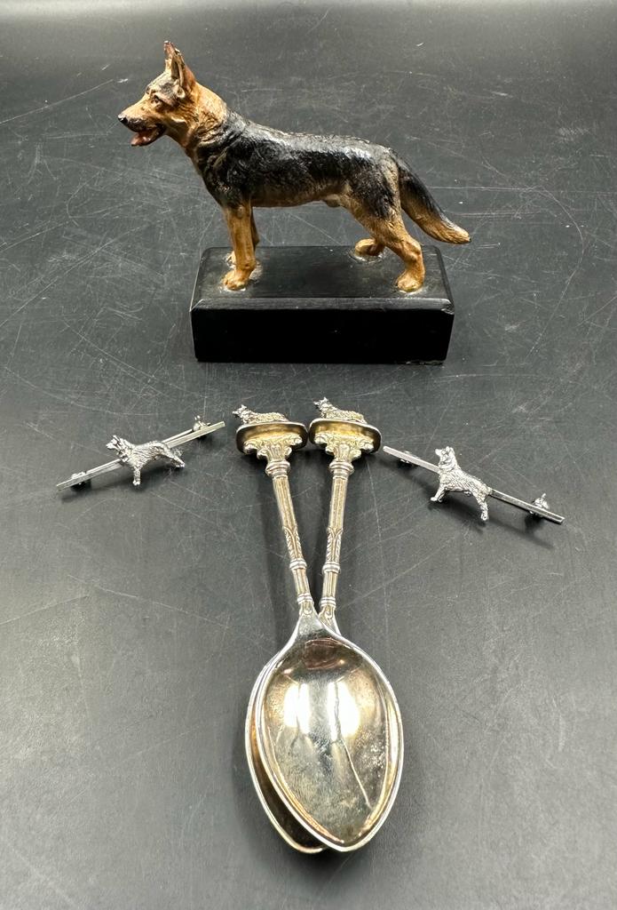 A selection of themed items an Alsatian trophy, two brooches and two tea spoons