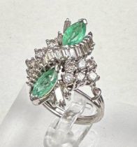 An emerald and diamond ring, designed a s a vertically set elongated cluster with two marquise cut