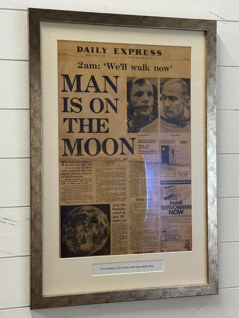 A framed front cover of The Daily Express dated July 21st 1969 "Man is on the Moon" (52cm x 77cm)