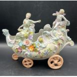 A ceramic ornament of a carriage in the style of Capodimonte