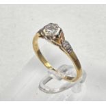 An 18ct and platinum set diamond ring with central stone and shoulders Size M