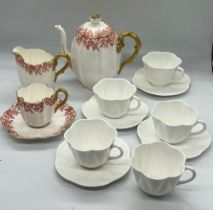 Four Shelley white tea cups and saucers and a Coalport teapot, milk jug and cup and saucer