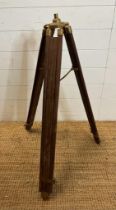 A vintage wooden and brass extendable tripod