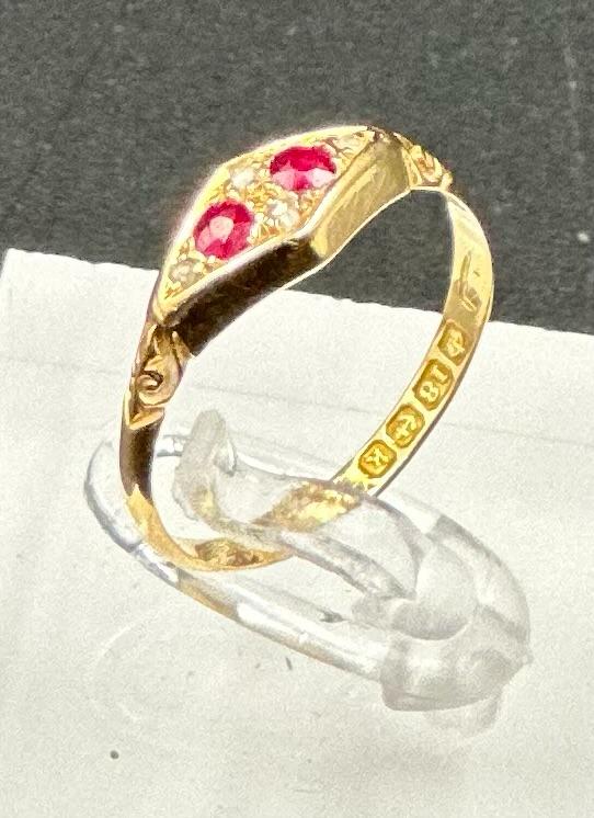 An 18ct gold antique ring with inset rubies and ornate design, approximate total weight 2.1g and