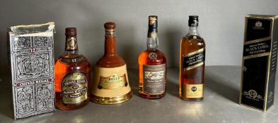 A selection of four whiskies: Johnnie Walker Black label, Chivas Regal, Bell's blended in a bell,