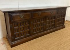 An Arts and Crafts style sideboard, one long central drawer flanked by two shorter drawers and three