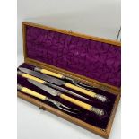 A cased carving set with white metal tips decorated with stags and game birds