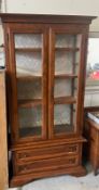 A glass display cabinet with two long drawers to base (H190cm W102cm D38cm)