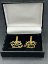 A pair of 18ct gold cuff links with central green stones, hallmarked for London, bearing the