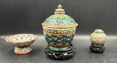 Three Chinese style ceramic items, two lidded jars and a stem dish in the famille rose palette