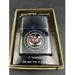 A boxed Zippo lighter with crest of the USS John F Kennedy