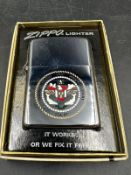 A boxed Zippo lighter with crest of the USS John F Kennedy