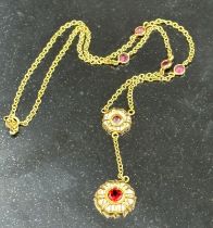 A 14ct gold necklace with garnet pendant and interspaced stones. Approximate total weight 4.5g.